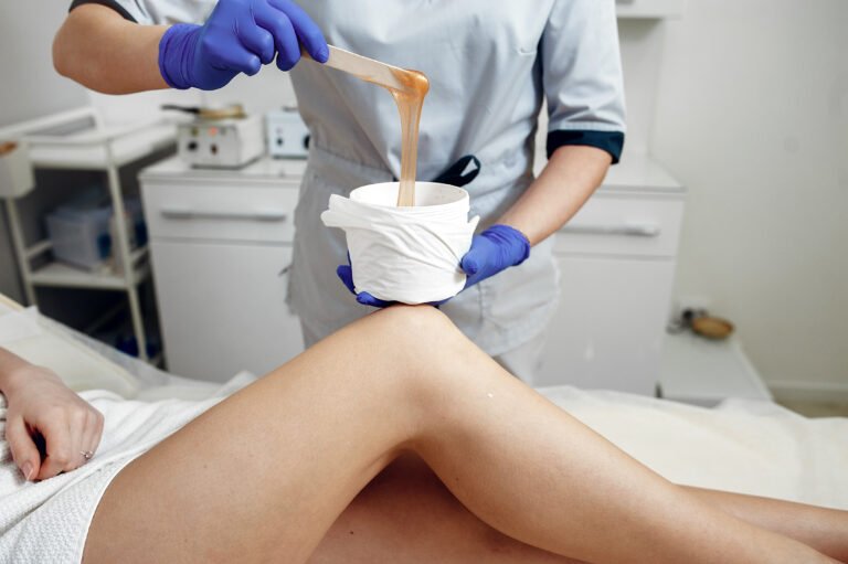 Beautiful girl doing hair removal. Woman in beauty salon